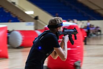 Игрок LASERWAR с оружием в движении за укрытием.